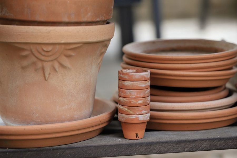 Vasos de barro e cerâmica empilhados numa bancada de varanda